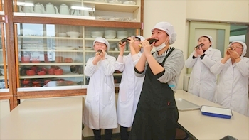写真：手巻き寿司にかぶりつく5名の学生