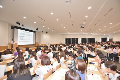 写真：会場いっぱいの1年生に向かって講演をする岸本先生