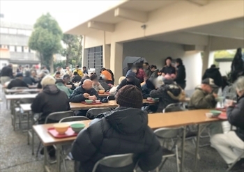 写真：炊き出しのご飯を食べる大勢の人