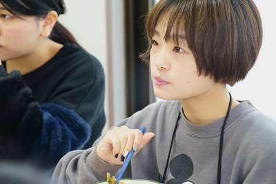 写真：食事を食べながら栄養教育を熱心に聞き入る食事の提供を受けた学生