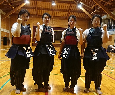写真：ガッツポーズで気合を入れる谷元・絹田・青井の3選手と山根監督