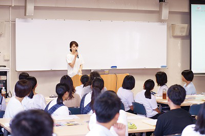 写真：食物学科の学科イベントで卒業生が管理栄養士として働く様子ややりがいを説明