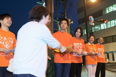 写真：通行人にチラシを配布する