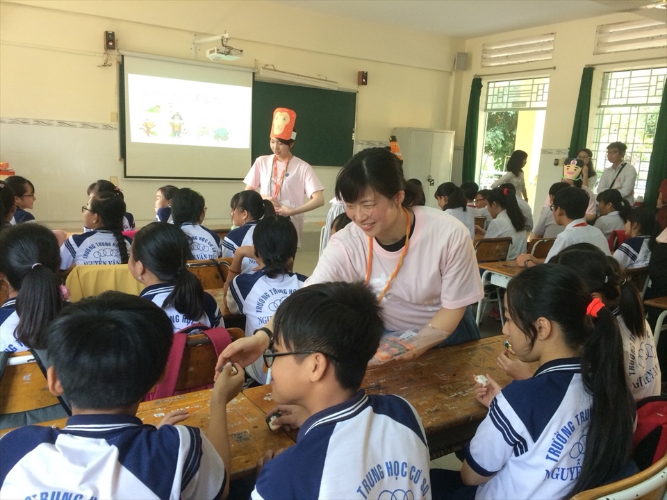 写真：学生が生徒にきびだんごを渡している様子