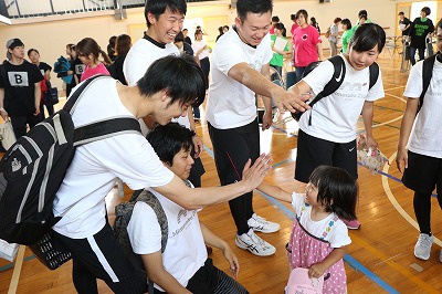 写真：閉講式を終えて学生とハイタッチをしてお別れをする子ども