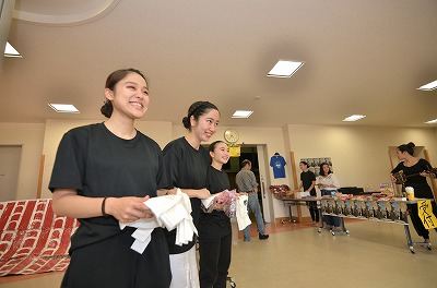 写真：笑顔で来場者をお出迎え