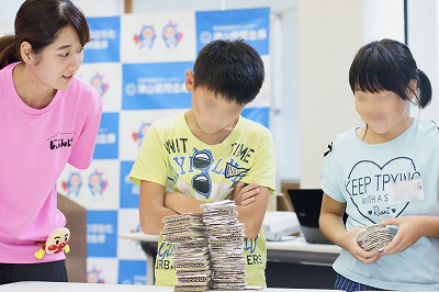 写真：子どもたちがゲームをとおして理解を深めている。学生はそばで見守る