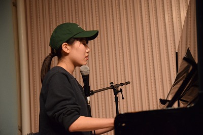 ステージで楽器を演奏し歌う学生