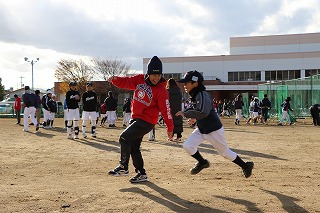 写真：走塁練習する参加者と、アドバイスするコーチ