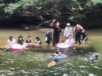 子ども達と川遊びをする部員達