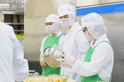 写真：調理担当の学生に盛り付けを指示する管理栄養士役の学生