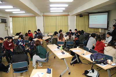 写真：教室でグループごとに座って、グループワークを行う学生たち