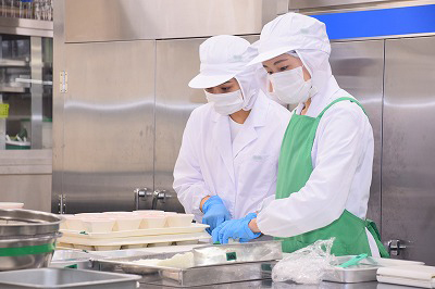 写真：調理担当の学生が丁寧に盛り付ける様子