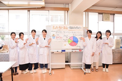 白衣を着た学生が講義をする様子