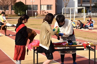 写真：机の上の衣装に着替える学生たち