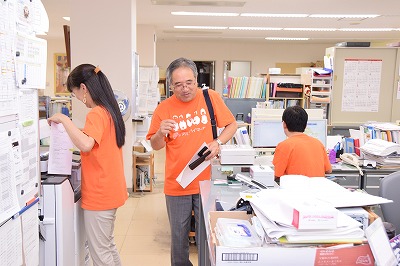 オレンジティーシャツを着ている職員