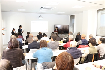 写真：スライドを使って里親制度について説明する2名の学生