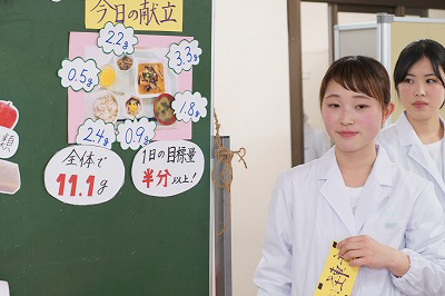写真：移動式ホワイトボードに資料を貼り付ける学生
