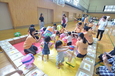 写真：手作りの風船ボールがいっぱいのスペースで子どもたちと遊ぶ学生たち