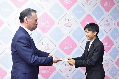 写真：激励金を受け取る比嘉さん