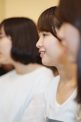 写真：ワクワクした表情でおもちゃを見る学生