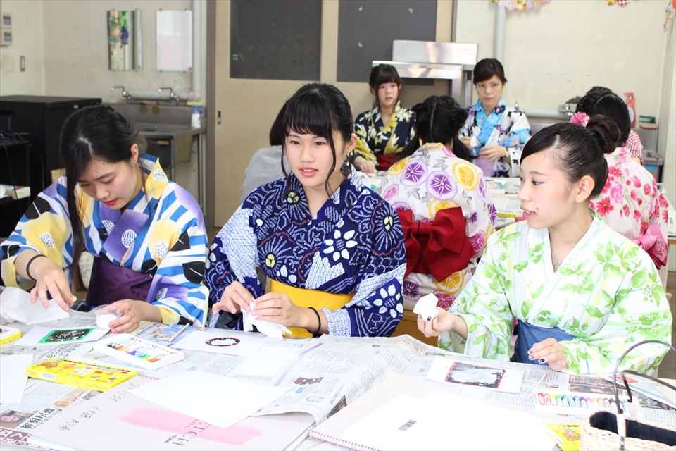 写真：浴衣を着た3名の女子学生が工作をする様子