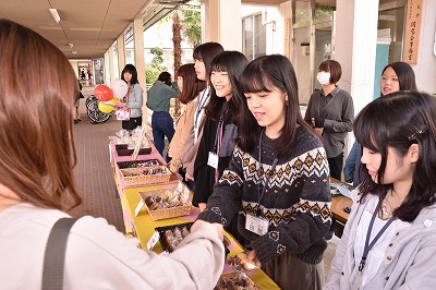 写真：商品を渡したり、お釣りを渡したりする学生