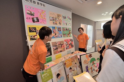 写真：学科の展示物の前で説明する学生
