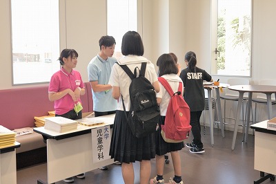 写真：受付をする参加者と対応する学科スタッフの学生