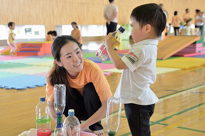 写真：手作りのおもちゃで一緒に遊ぶ学生