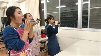 写真：手巻き寿司にかぶりつく3名の学生