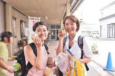 写真：買ったものを見せてくれる学生2名