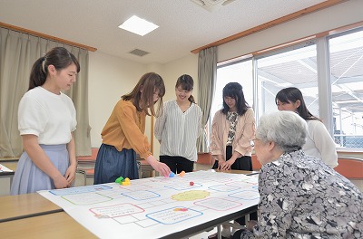 写真：食品ロス削減スゴロクを参加者と一緒にする学生