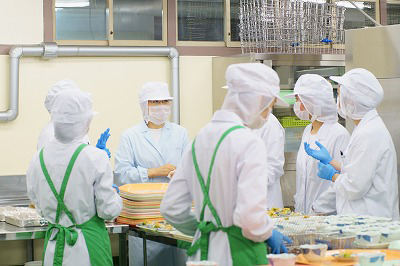 写真：大量調理中、提供手順や作業手順を調整する学生たち
