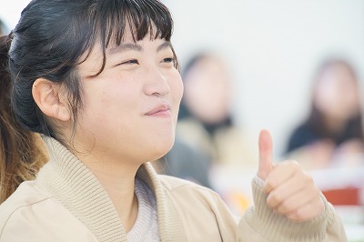 写真：栄養教育を熱心に聞き、よくわかった合図をする学生