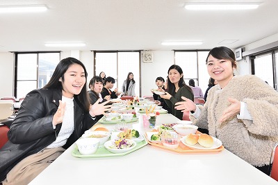 写真：提供された食事を指し示す学生