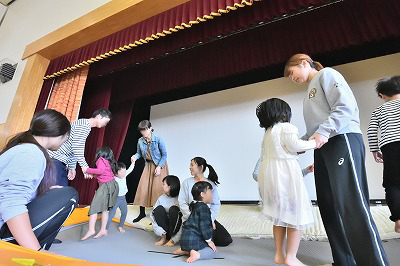 写真：トランポリンで飛び跳ねる子どもと学生