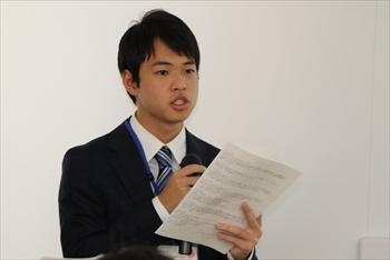 写真：マイクを使って里親制度について説明する1名の男子学生