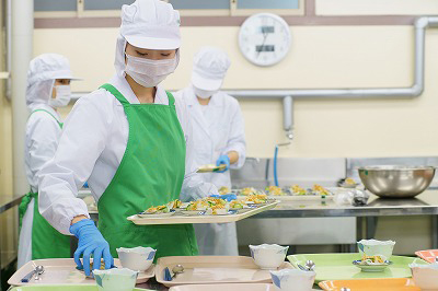 写真：調理担当の学生が丁寧に盛り付ける様子
