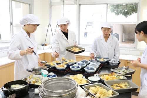 写真:天ぷらを調理する4名の女子学生