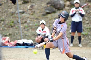 写真：バットでボールを打つ選手