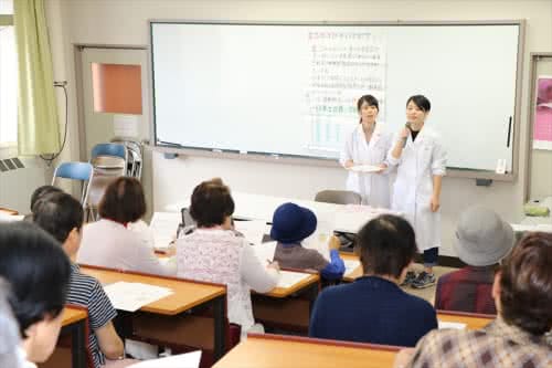 写真:教壇で食品ロスについて話す2名の学生