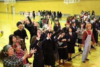 写真：お菓子投げでお菓子をつかもうとする大勢の学生