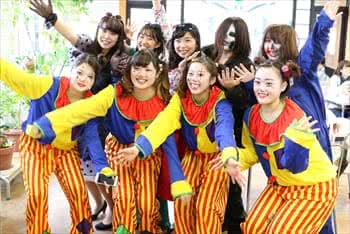 写真：ピエロの格好をした学生が手を広げてポーズしている様子