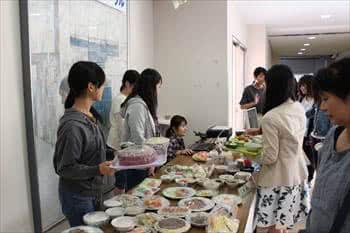 写真：並べられた料理とそれを見る人たち