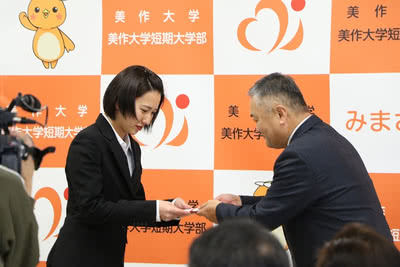 ライオンズクラブ中島氏から寄付金を受け取る学生