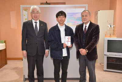 立正佼成会 津山教会長の東伸吉様から寄付金を受け取る学生