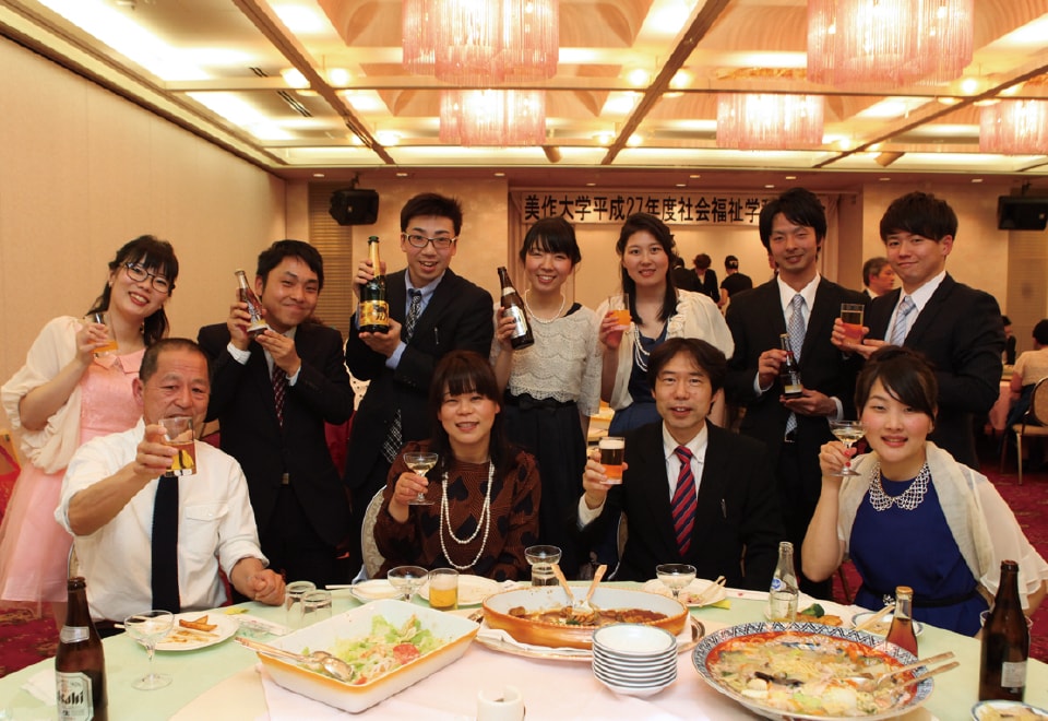 写真：謝恩会で料理を前にした教師と生徒たち。