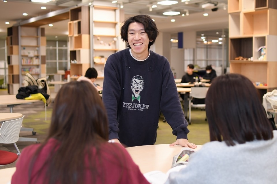 写真：他の学生と話すMさん