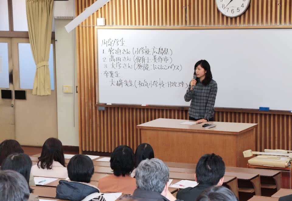 写真：就職活動体験談の壇上で語る女子卒業年次生と、それを聞く学生たち